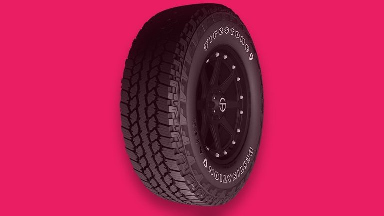 Firestone Destination A/T2 all-terrain tire on a hot pink background